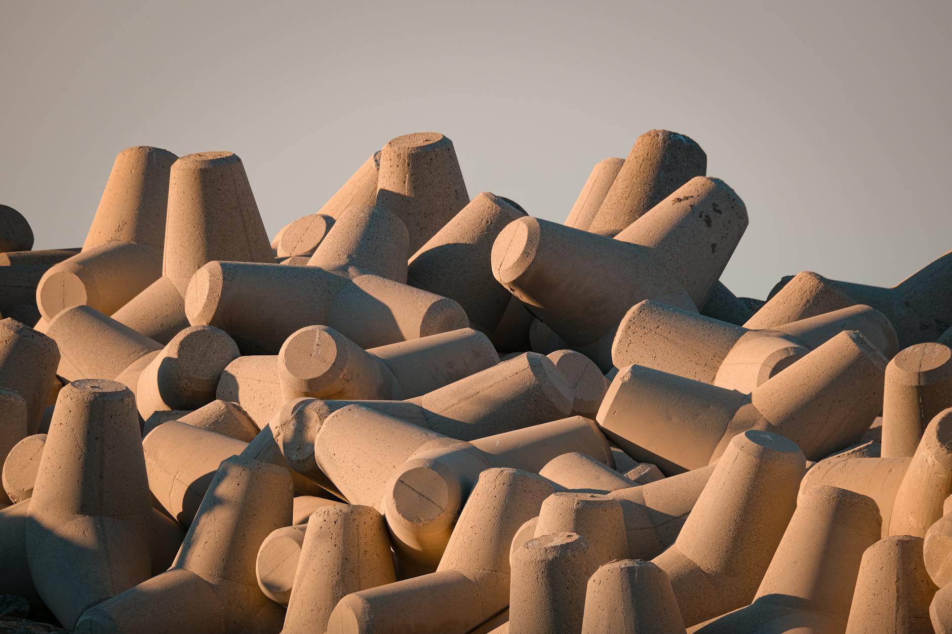 Betonowe tetrapody na falochronie w ciepłym świetle zachodu słońca