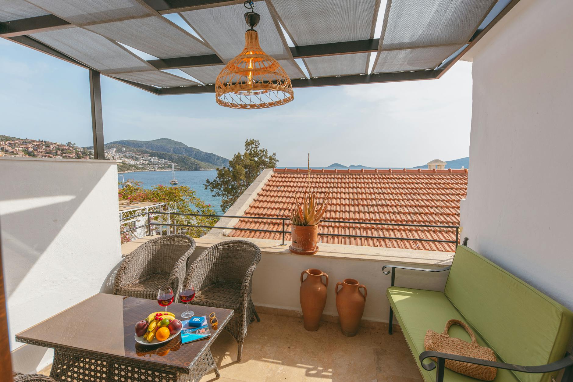 Taras WPC z zadaszeniem: jak zaplanować spadki, rynny i odprowadzenie wody spod desek Nowoczesny taras WPC z widokiem na morze latem