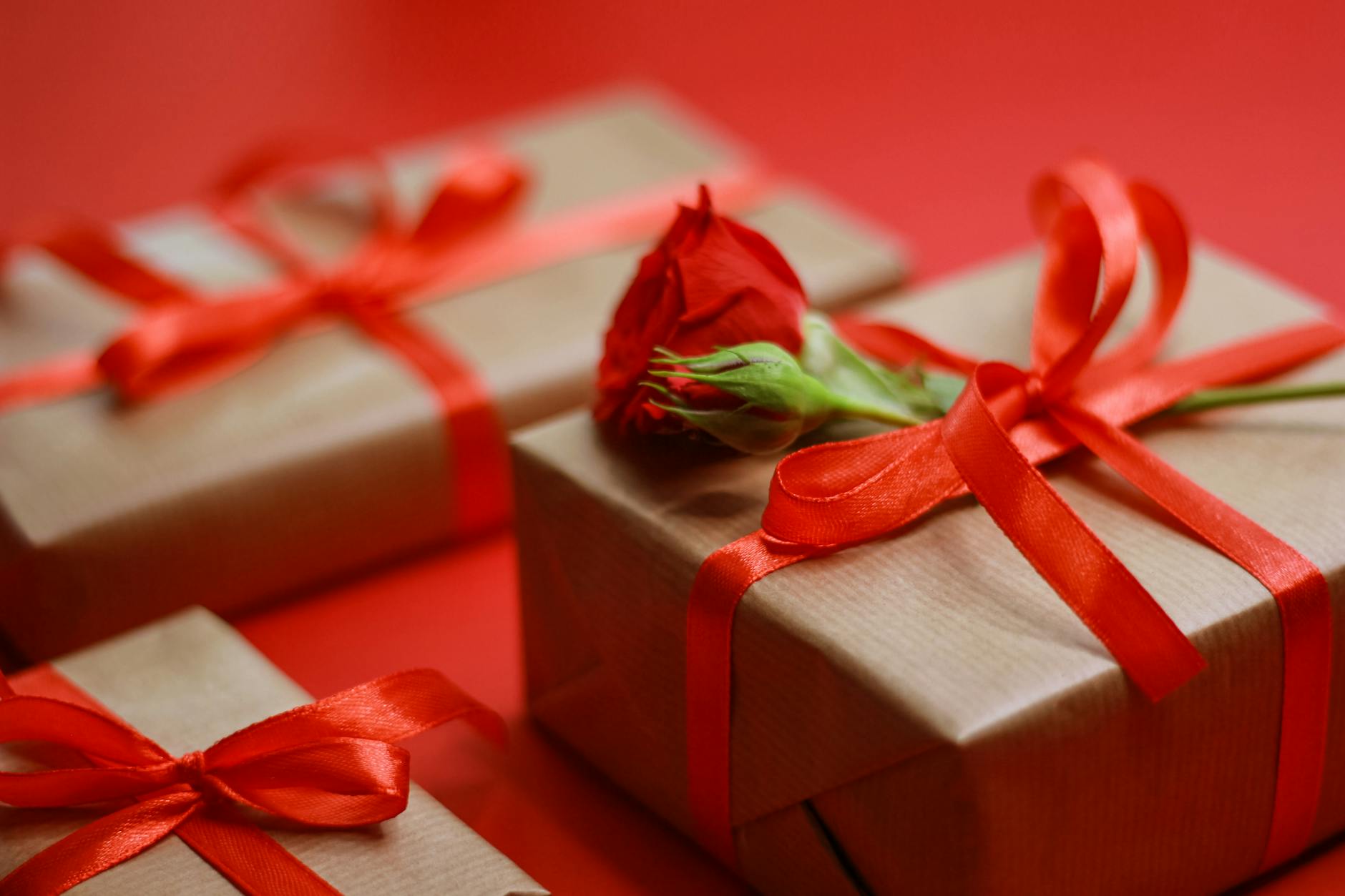 Eleganckie pudełka prezentowe z czerwonymi wstążkami i różą