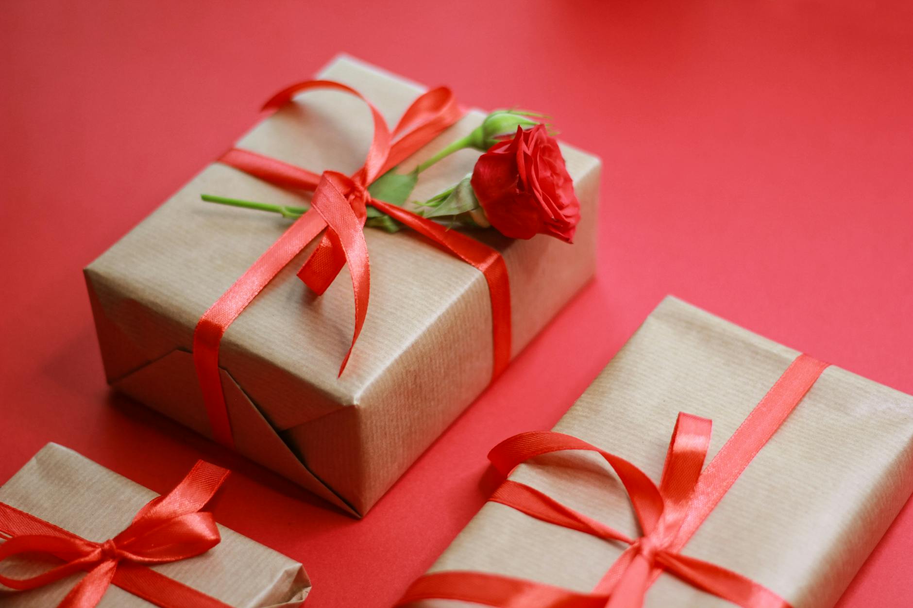 Eleganckie pudełka prezentowe z czerwonymi wstążkami na czerwonym tle