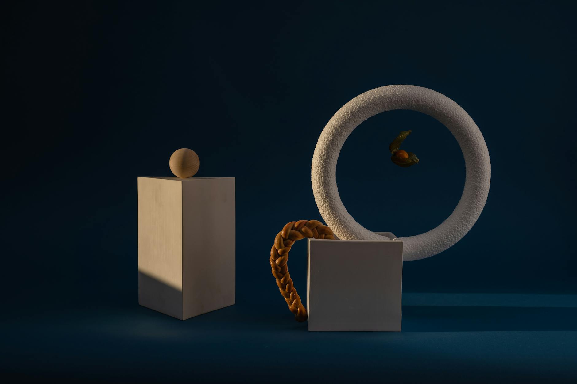 Geometryczne kształty na ciemnoniebieskim tle, minimalistyczna kompozycja