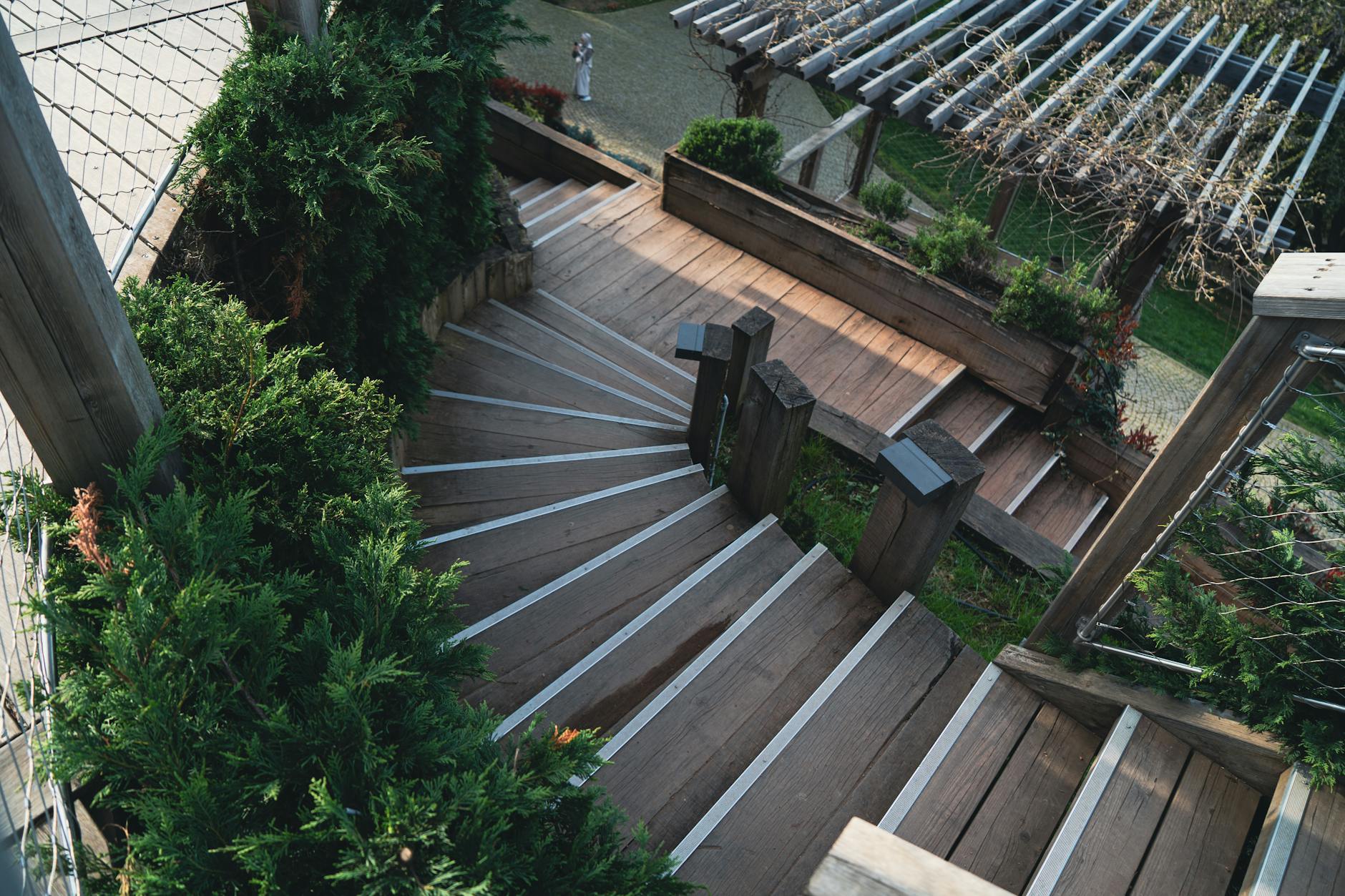 Drewniane schody tarasowe otoczone bujną roślinnością w ogrodzie