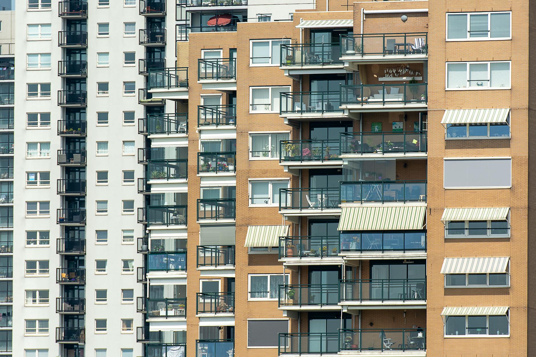 Nowoczesna elewacja bloku z balkonami w gęstej zabudowie miejskiej