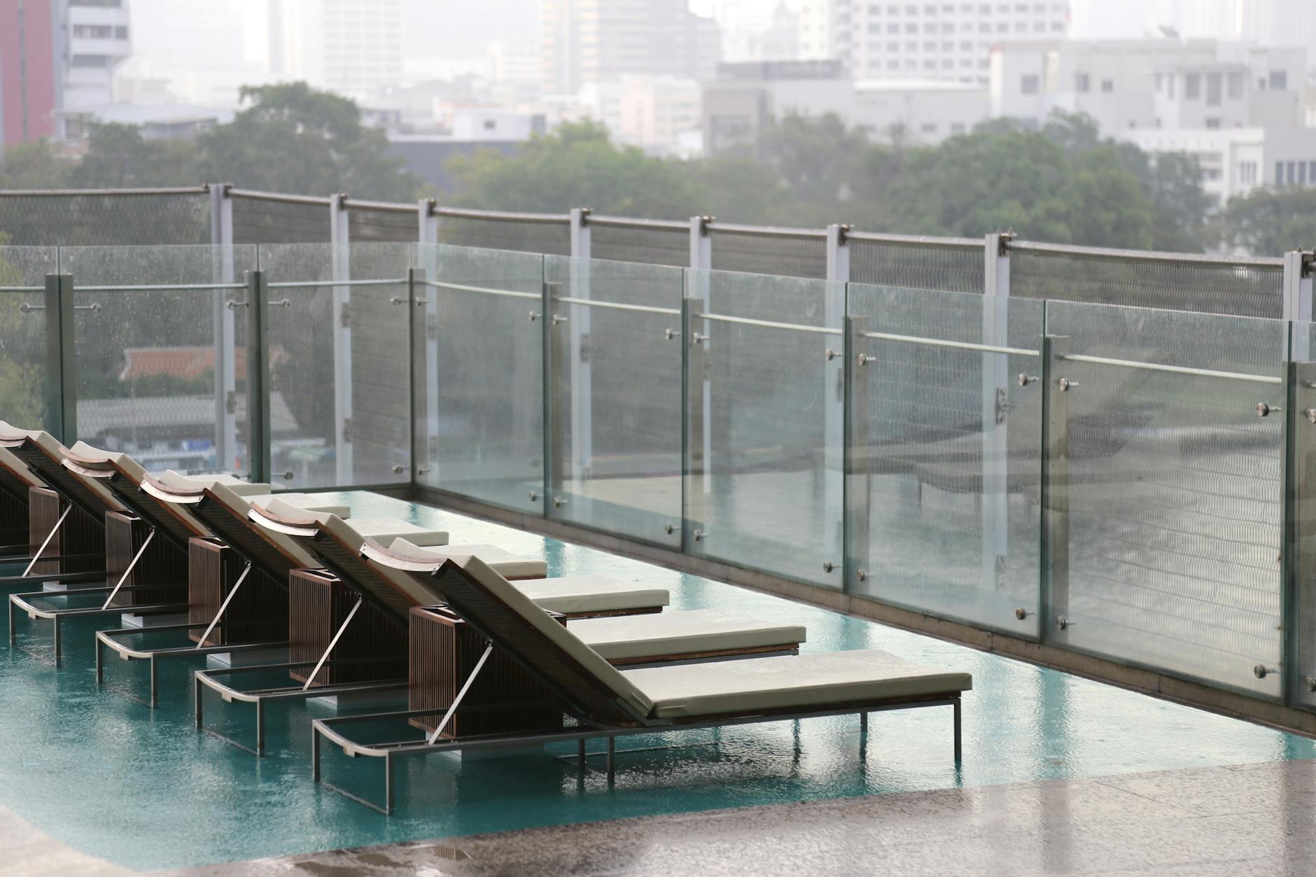 Nowoczesny taras kompozytowy z leżakami przy basenie w mieście