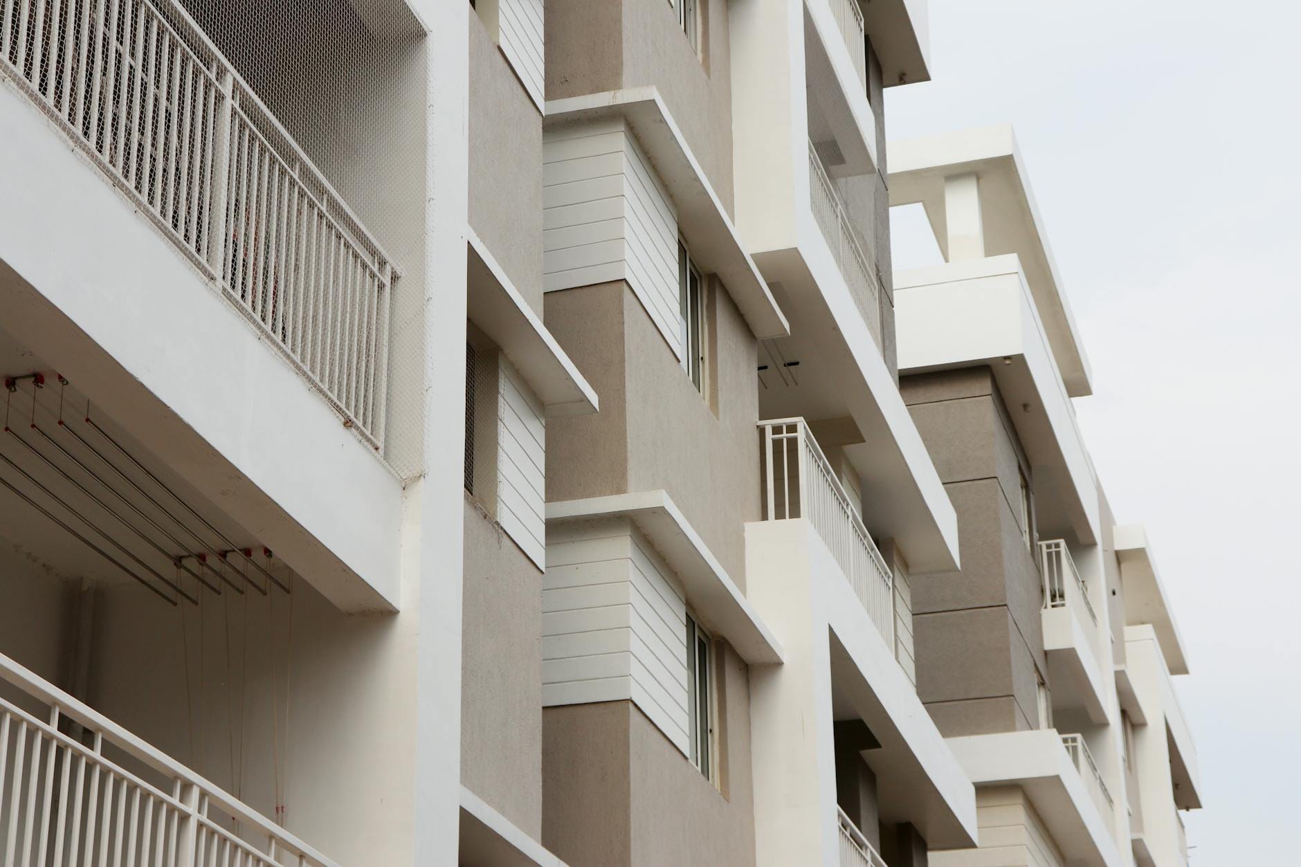 Balkon z WPC w ekspozycji południowej: dobór koloru, wentylacja i ochrona przed przegrzewaniem Nowoczesne bloki mieszkalne z balkonami w słonecznej miejskiej zabudowie