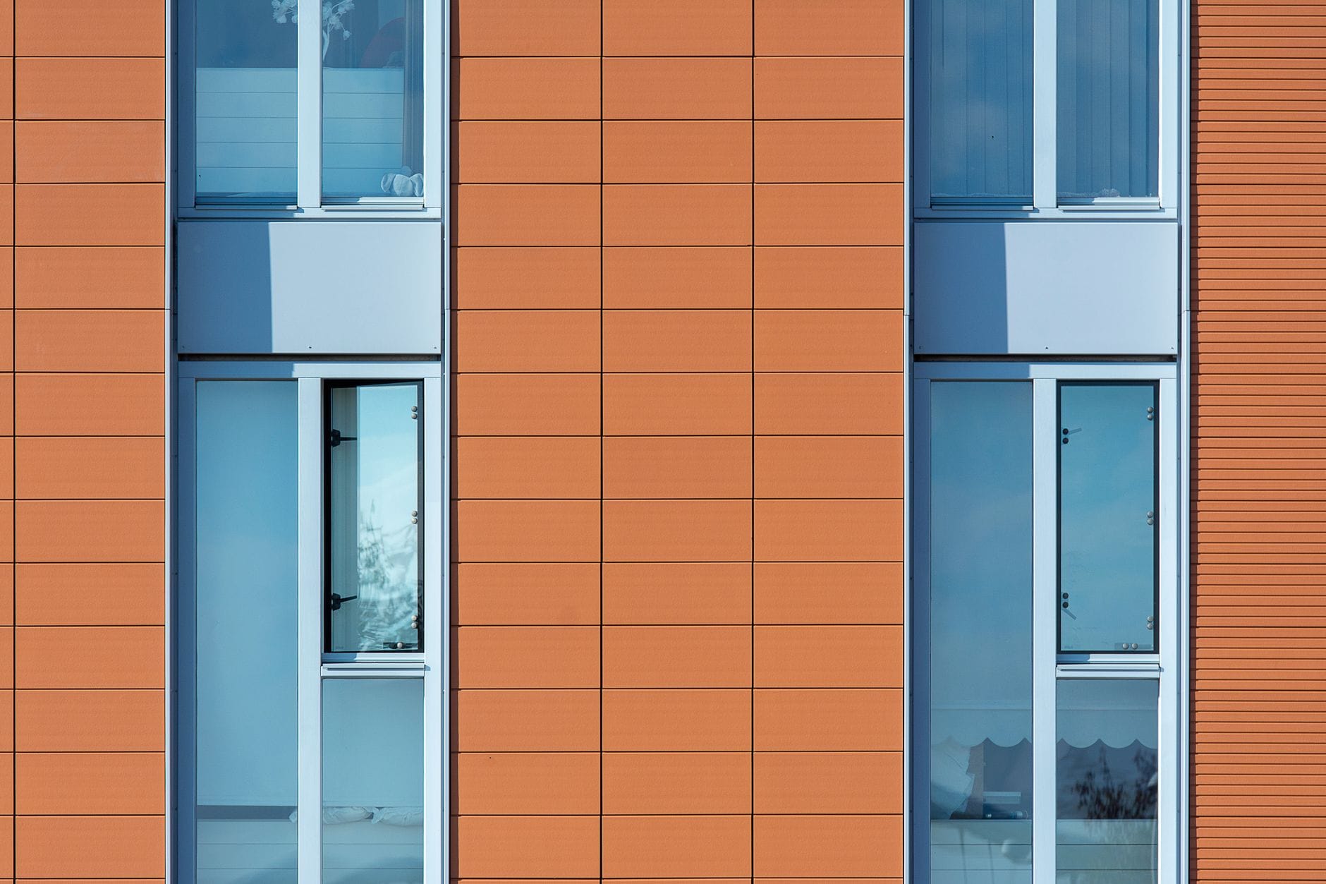Nowoczesna elewacja z dużymi oknami i geometrycznym układem paneli