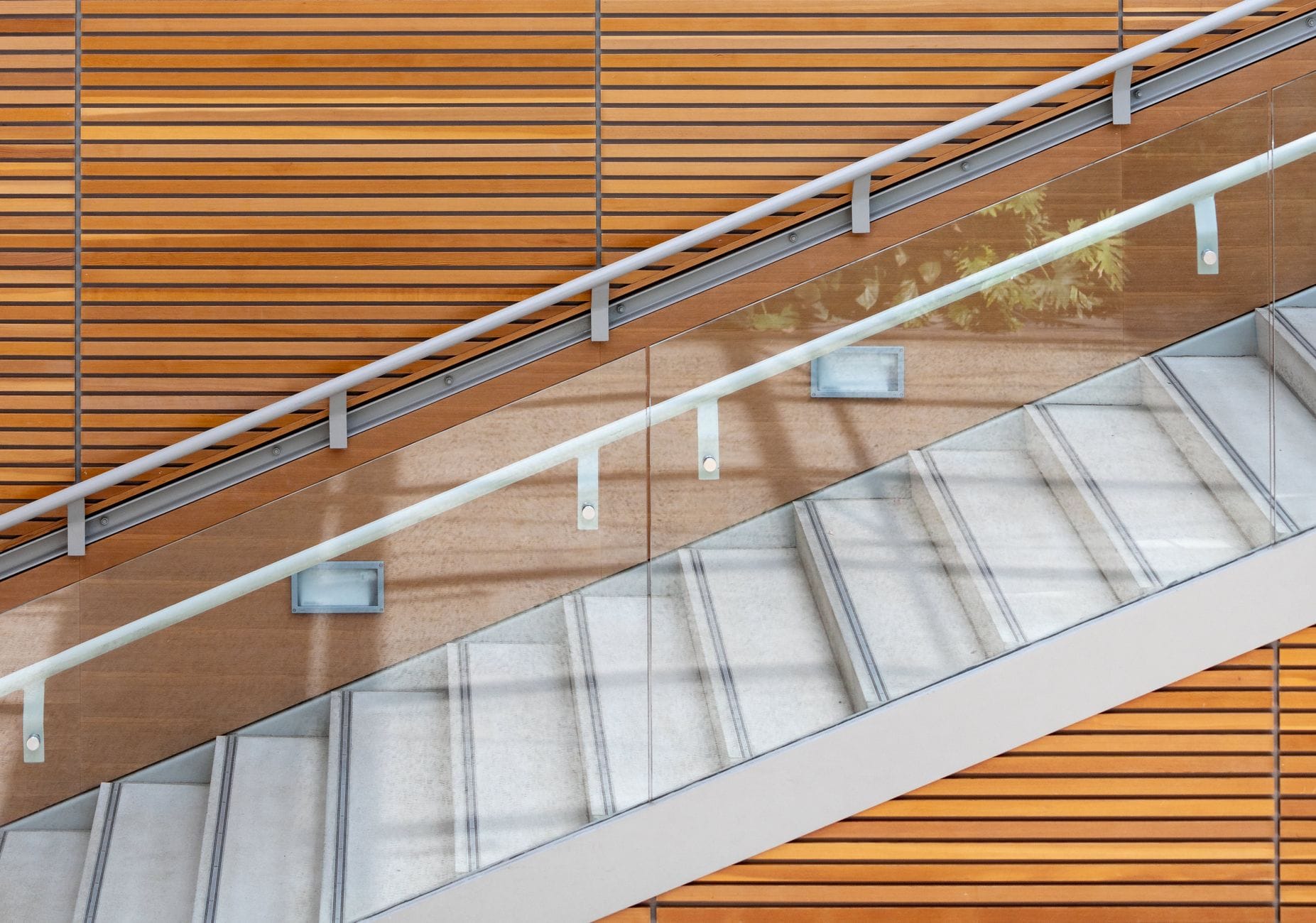 Nowoczesne schody z paneli WPC z przeszkloną balustradą