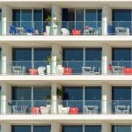 Kolorowe balkony nowoczesnego hotelu z roślinami i stolikami
